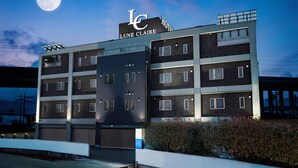 A multi-story hotel with a prominent "Lune Claire" sign, featuring a modern architectural design with a mix of brick and glass facades. - Hotel LUNE CLAIRE - Adults Only (Chikuma)