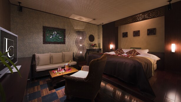 A hotel room with a bed, a sofa, a chair, a small table, and a TV. - Hotel LUNE CLAIRE - Adults Only (Chikuma)