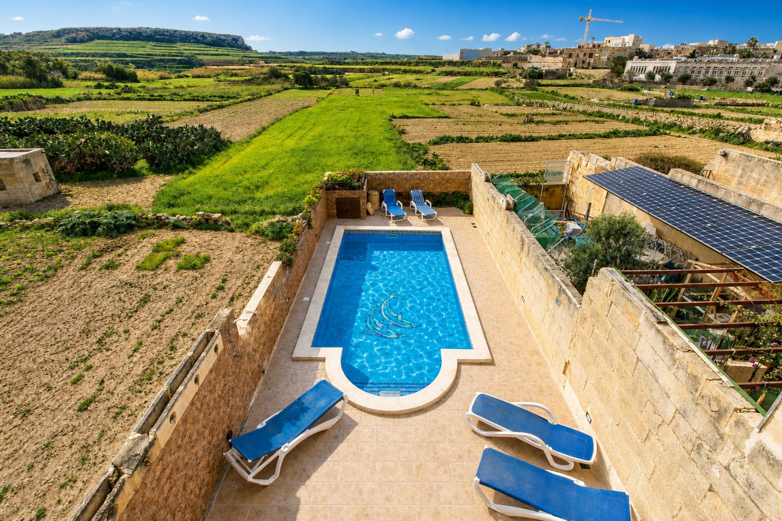 A swimming pool with lounge chairs and a view of the countryside.