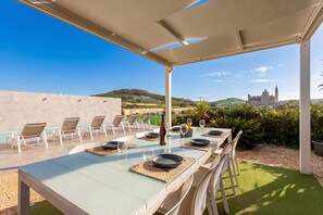 An outdoor dining area with a view of a hill and a building in the distance.