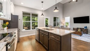 A modern kitchen with granite countertops, a built-in oven, and a large island with a sink. - Peaceful Lake Home on TIms Ford (Tullahoma)