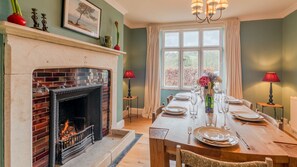 Enjoy meals by the fireplace in this cozy dining room with a large table and a beautiful view.