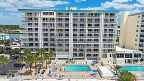 Un hôtel à plusieurs étages doté d’une piscine, d’un espace extérieur aménagé et offrant une vue sur l’eau.