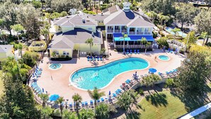 An aerial view of a resort with a large swimming pool, multiple lounge areas, and a variety of trees and greenery. - Luxury 3BR Caribbean Retreat nr Disney (Davenport)