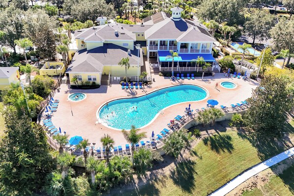 An aerial view of a resort with a large swimming pool, multiple lounge areas, and a variety of trees and greenery. - Luxury 3BR Caribbean Retreat nr Disney (Davenport)