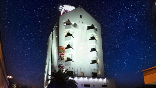 Un edificio alto con varios balcones y un cielo estrellado.