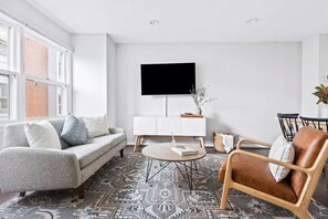 Relax in this stylish living room with a sofa, armchair, and flat-screen TV.