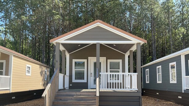 A single-story mobile home with a porch, a front door, and a small set of stairs leading up to the entrance. - Tiny Homes for Rent, minutes to the Casino, Golf Course & Water Park.
 (Philadelphia)