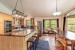 A modern kitchen with wooden cabinets, stainless steel appliances, and a large island.