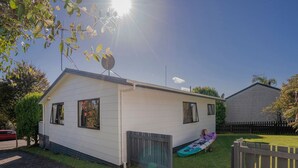 Una casa mòbil de planta baixa amb antena parabòlica, un petit porxo i una tanca al pati.