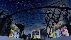 A starry night sky with a modern building featuring a large illuminated sign and a view of the interior. - Restay Koriyama - Adults Only (Koriyama)