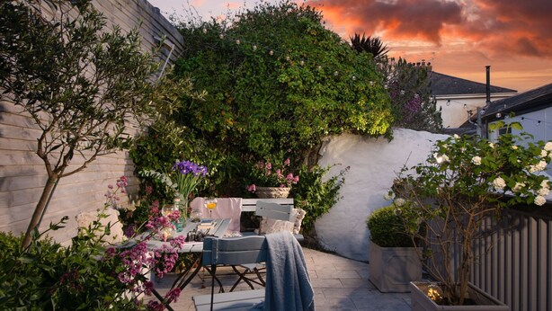 A patio with a table and chairs, surrounded by plants and flowers. - Carvossa - Sea Views & Woodburner (Marazion)