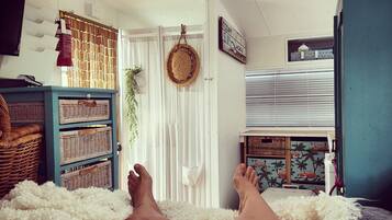 Relax in this serene bedroom with a comfortable bed, wicker storage, and a balcony view.
