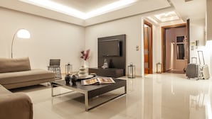 Una sala de estar moderna con sofá, mesa de centro y televisor de pantalla plana.