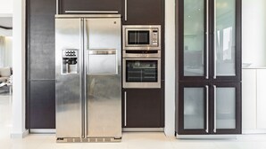Una cocina moderna con refrigerador de acero inoxidable, microondas integrado y horno.