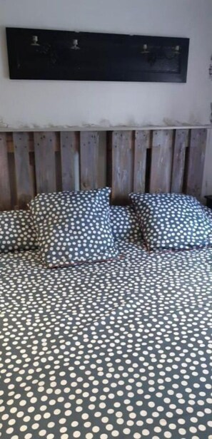 Un lit avec une couvre-lit à pois et une tête de lit en bois.