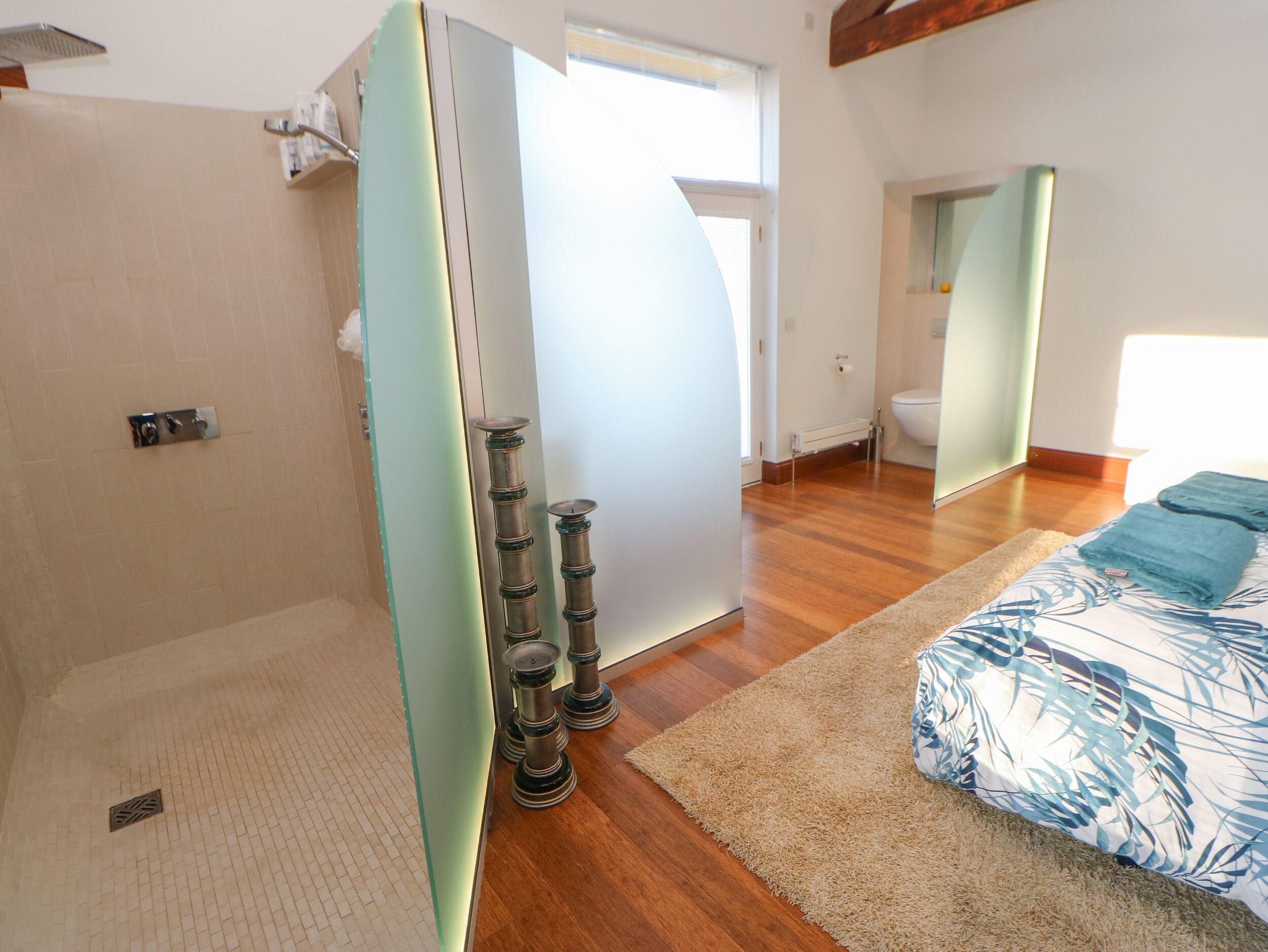 Un baño moderno con ducha, inodoro y mampara de vidrio.
