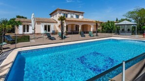 A poolside view of a Mediterranean-style villa with a swimming pool, lounge chairs, and a gazebo. - Massenet by Interhome (Saint Aygulf)
