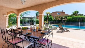 An outdoor patio with a table and chairs, a pool, and a house in the background. - Massenet by Interhome (Saint Aygulf)