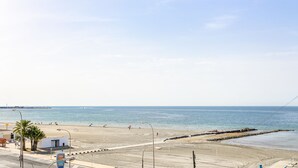 A beach with a clear sky, a few people, and a small building near the water. - ✩ direct beach location ✩ family friendly ✩ Netflix (Santa Pola)