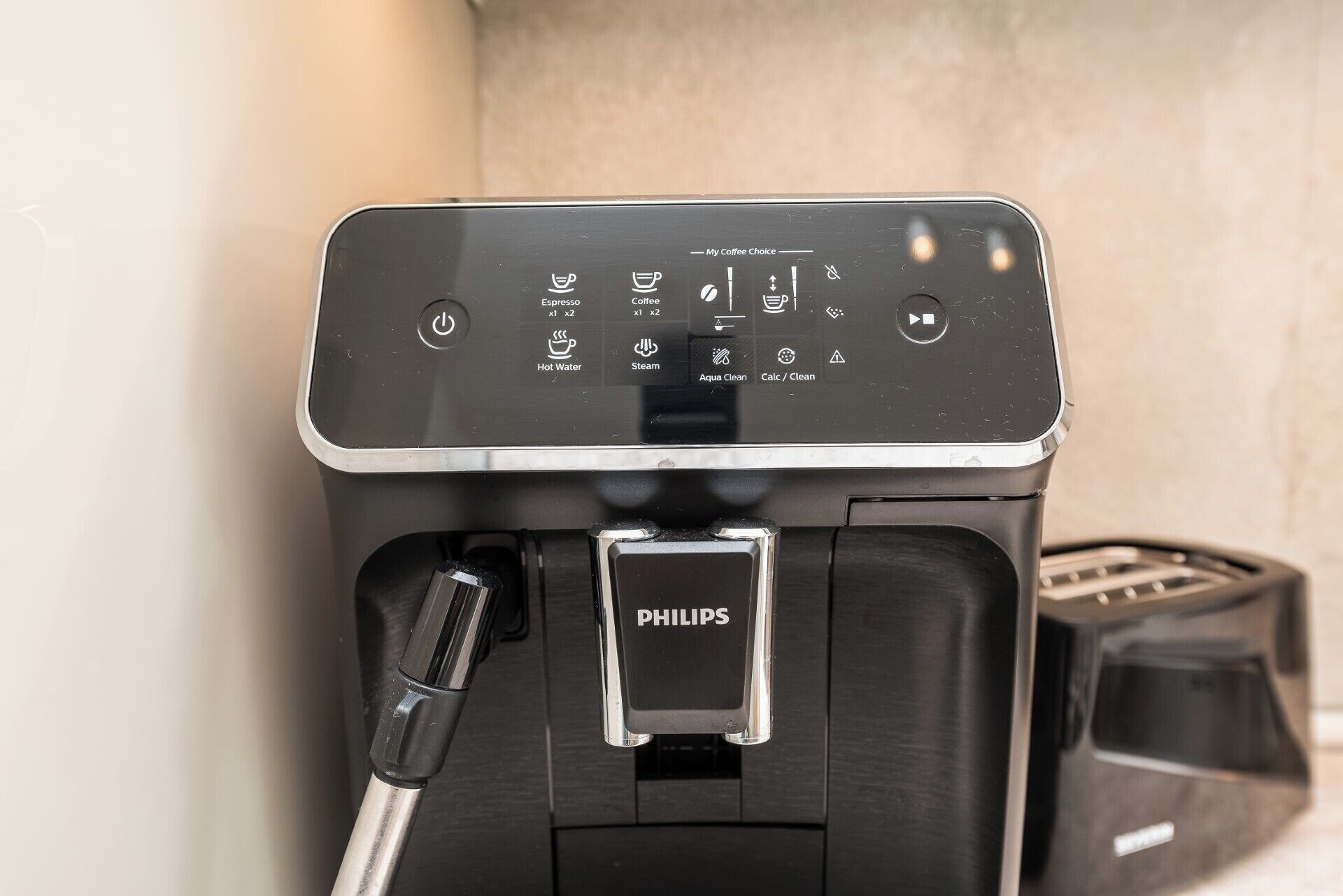 A Philips coffee machine with a control panel displaying options for espresso, coffee, hot water, steam, and cleaning functions.
