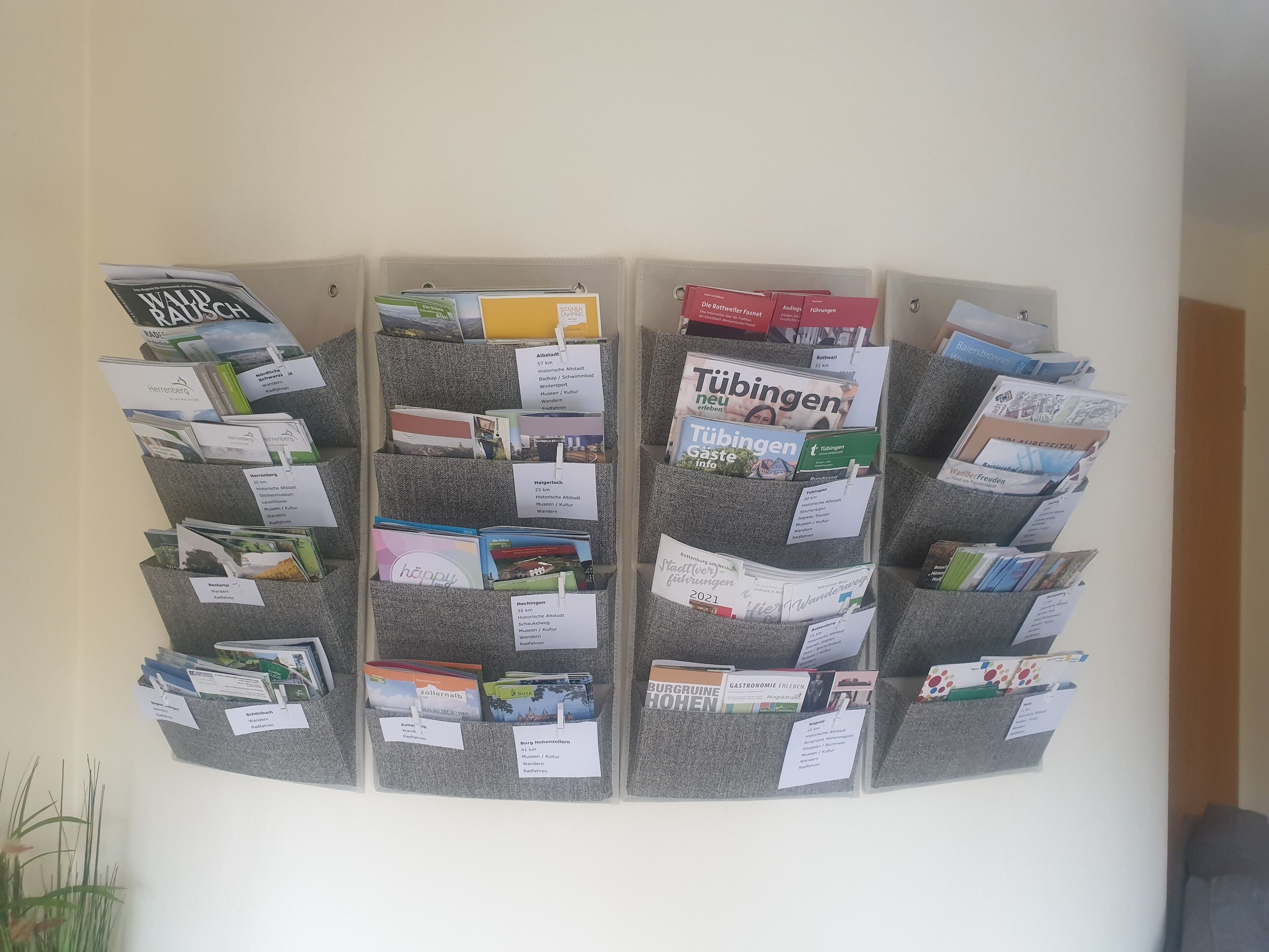 A bulletin board with various travel brochures pinned to it.