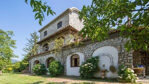 A stone building with a balcony, arched windows, and a garden with flowers. - Rocca Angelica - Villa with swimming pool, 40 min far from Positano (Santa Maria del Castello)