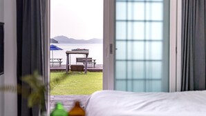 A bedroom with a view of a deck and a body of water. - Yeosu Arens Pension (Yeosu)