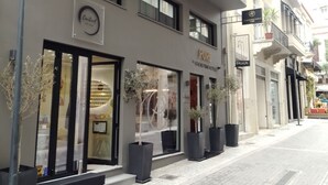Un edificio moderno con un cartel que dice 'Moment' y 'Athens Pure Hotels'.