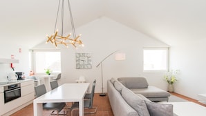 A modern loft-style apartment with a dining area, kitchen, and living space. - Convento das Bernardas Lux T2 (Tavira)