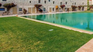 A hotel with a stone facade, a swimming pool, and a well-maintained lawn. - Convento das Bernardas Lux T2 (Tavira)