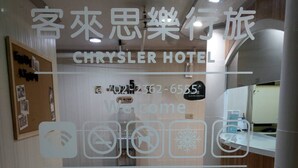 A hotel reception area with a marble floor, a reception desk, and a bulletin board.