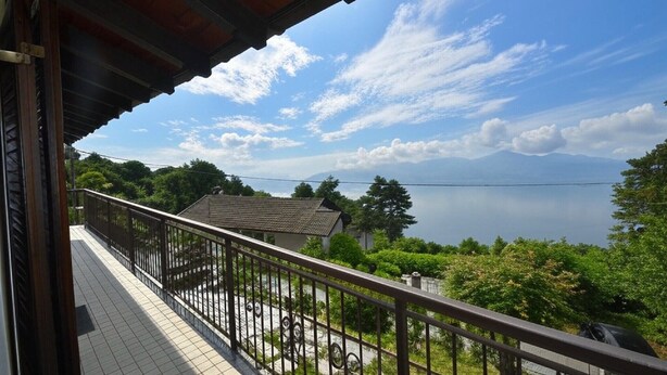 A balcony with a view of a lake and mountains.
