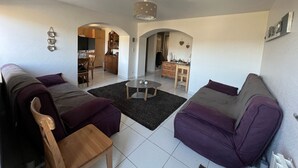 Ein Wohnzimmer mit einer Couch, einem Couchtisch und einem Essbereich mit Tisch und Stühlen.
