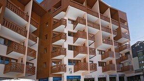 A multi-story hotel with balconies and a clear sky. - Spacious 3-room cabin, 6 pers, ski-in/ski-out, free parking (Les Belleville)