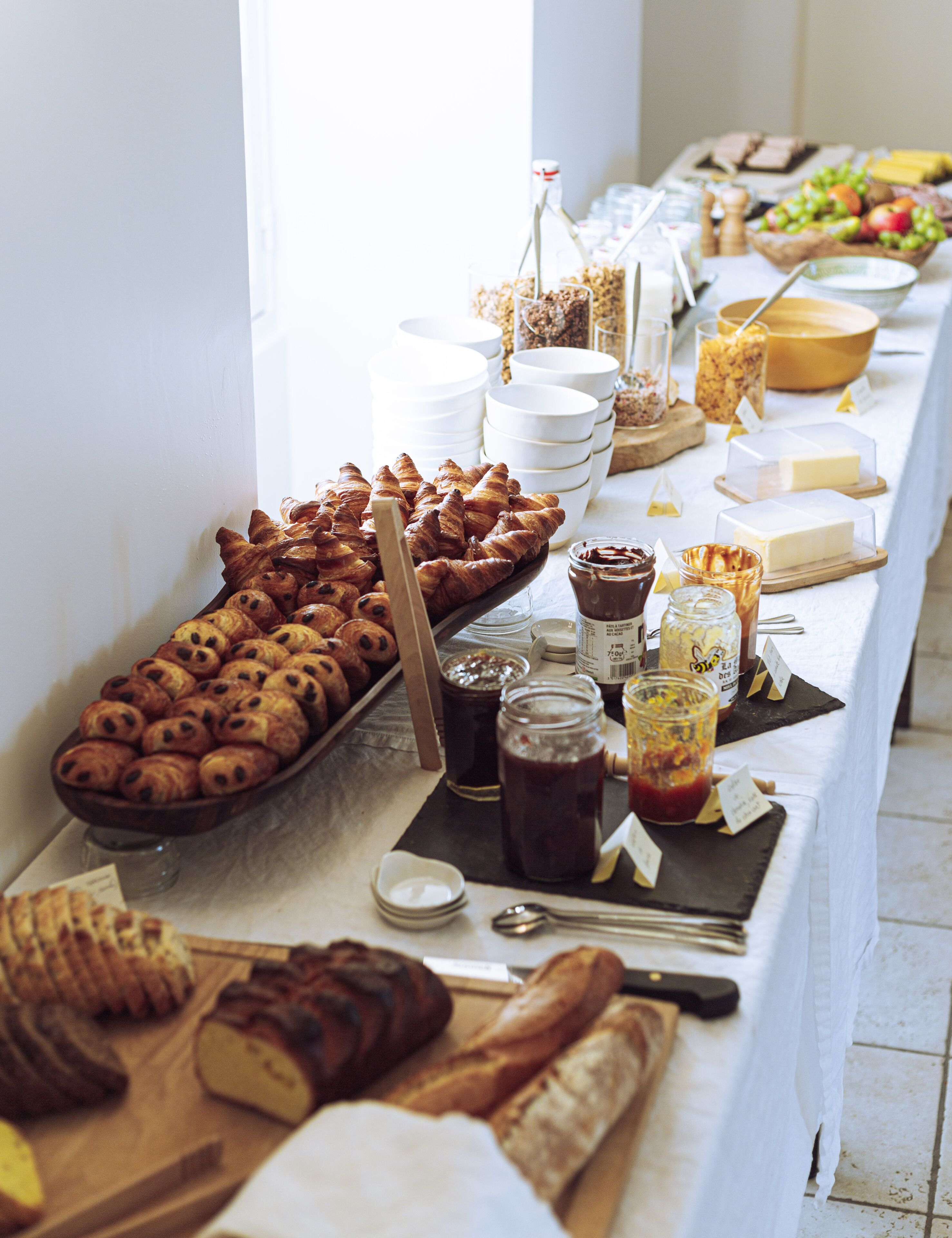 A buffet table with various food items and condiments.