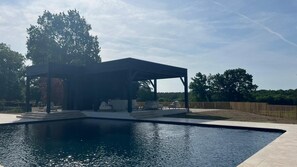 Piscine extérieure en saison, chaises longues