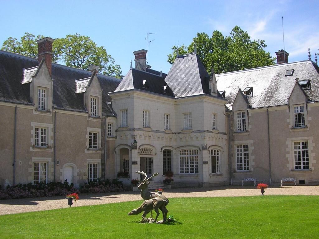 Een groot, historisch gebouw met meerdere schoorstenen en een symmetrische gevel.