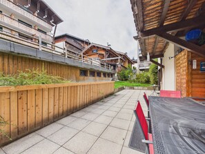 Um edifício de madeira com varandas, um pátio pavimentado e o letreiro de um restaurante.