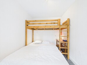 A bunk bed with a wooden frame, a white mattress, and a small bedside table with a lamp. - Prime Location Apartment - Center of Les Gets, Near Lifts, Terrace, Pet-Friendly, WiFi (Les Gets)