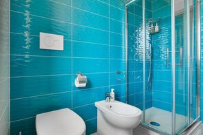 Une salle de bain équipée de toilettes, d’un bidet et d’une douche.