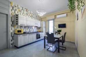 Una cocina moderna con comedor, televisor y una planta.