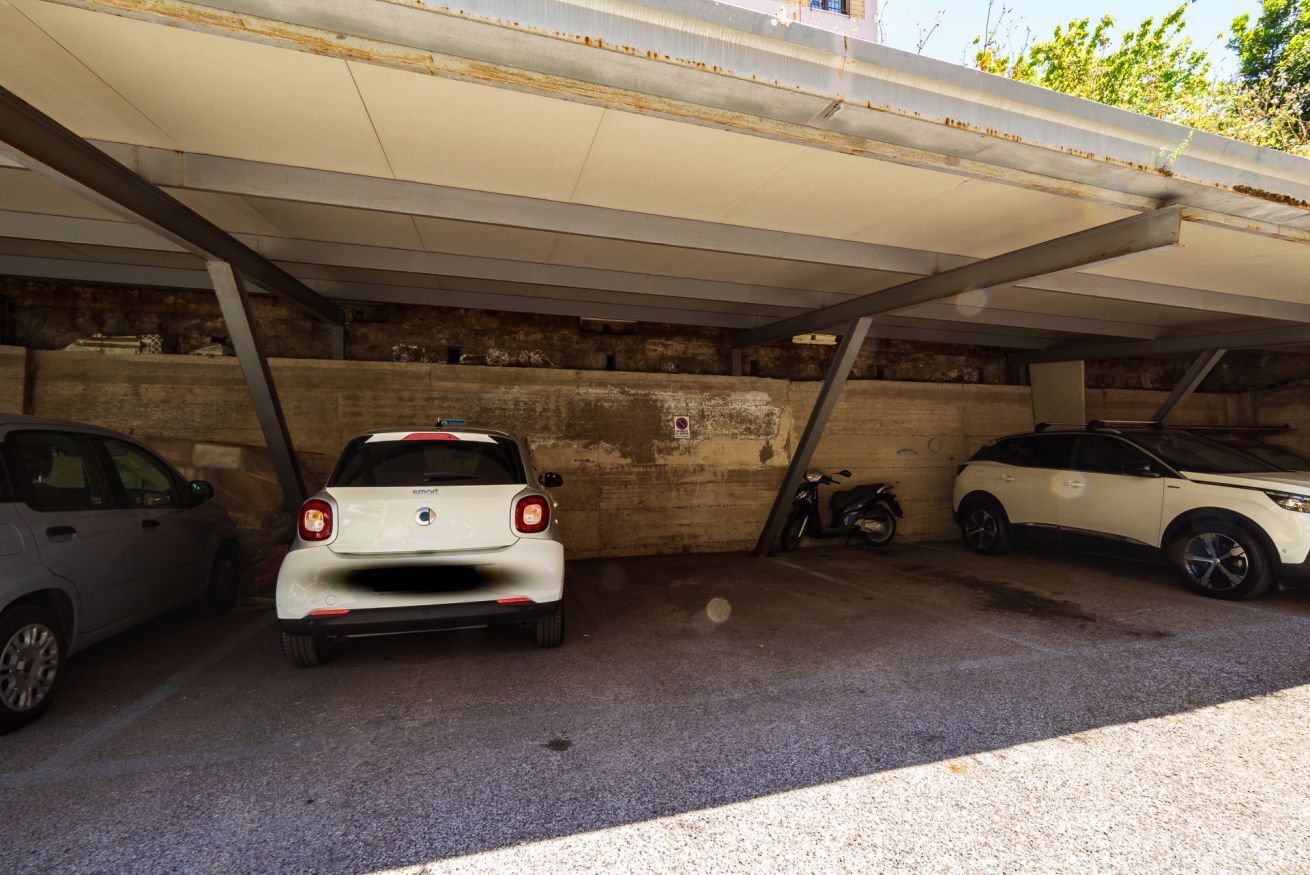 Eine Tiefgarage mit drei Autos unter einem Vordach.
