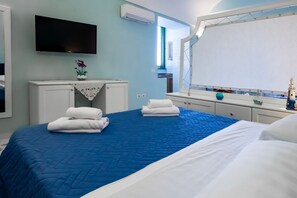 A hotel room with a bed, a TV, a vanity with a mirror, and a window. - Casa Mariarosa - Seaview House in Sorrento Coast (Piano di Sorrento)
