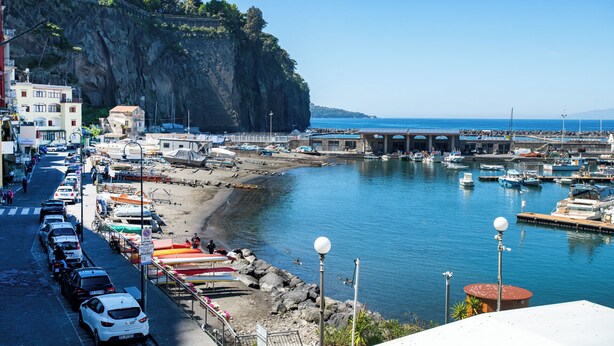 A coastal marina with boats, a rocky cliff, and a bridge. - Casa Mariarosa - Seaview House in Sorrento Coast (Piano di Sorrento)