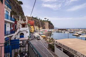 A coastal town with colorful buildings, a marina, and a bar restaurant.
