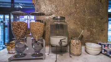 A breakfast bar with cereal dispensers, a milk dispenser, and bowls.