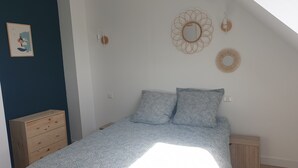 Une chambre à coucher comprenant un lit, une commode et un mur décoré de différents objets.