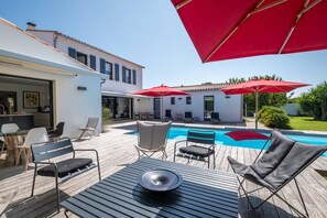Relax by the pool in an outdoor space with a deck, dining area, and comfortable seating.