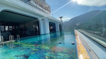 Una piscina al aire libre, sillones reclinables de piscina